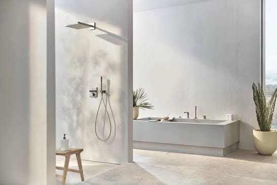 Grohe luxury bathroom with black tile, gold fixtures, double round mirrors and soaking tub