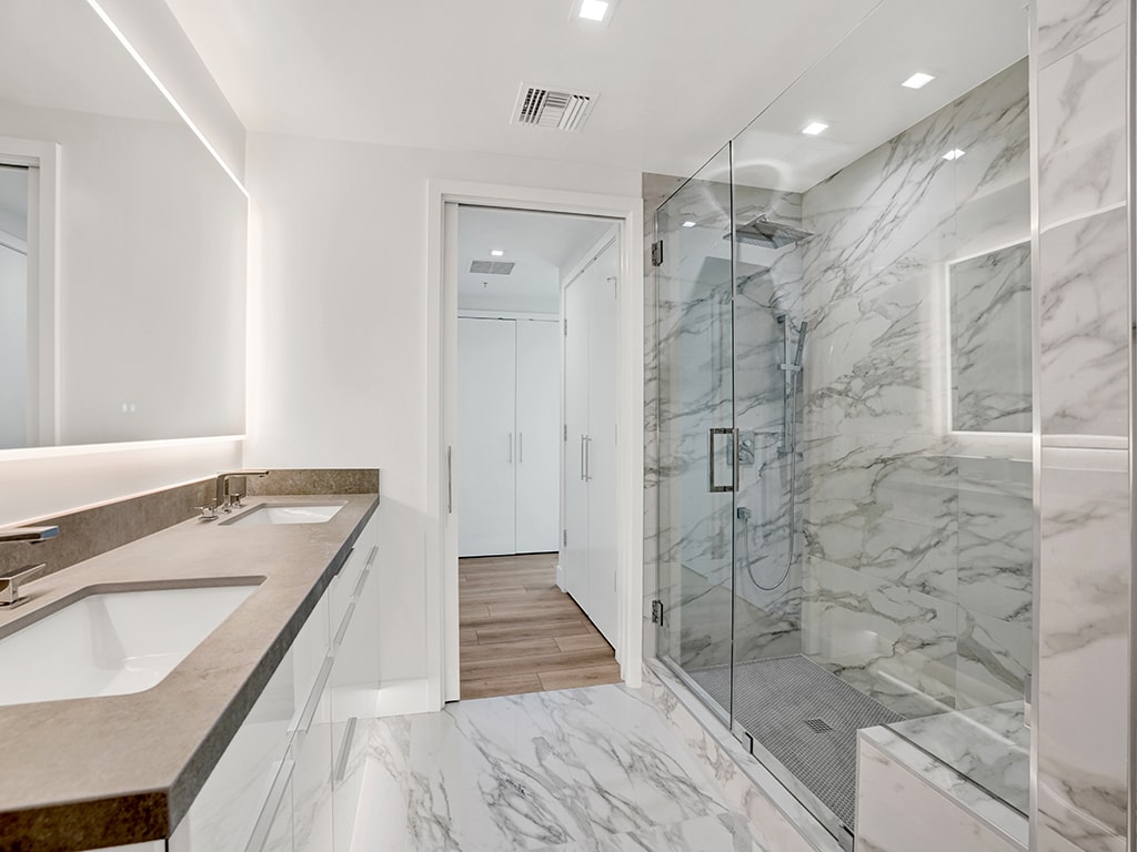 Bathroom remodel in Irvine CA — floor-to-ceiling large format tile shower, modern chrome fixtures, and floating vanity by Main Street Kitchen & Flooring