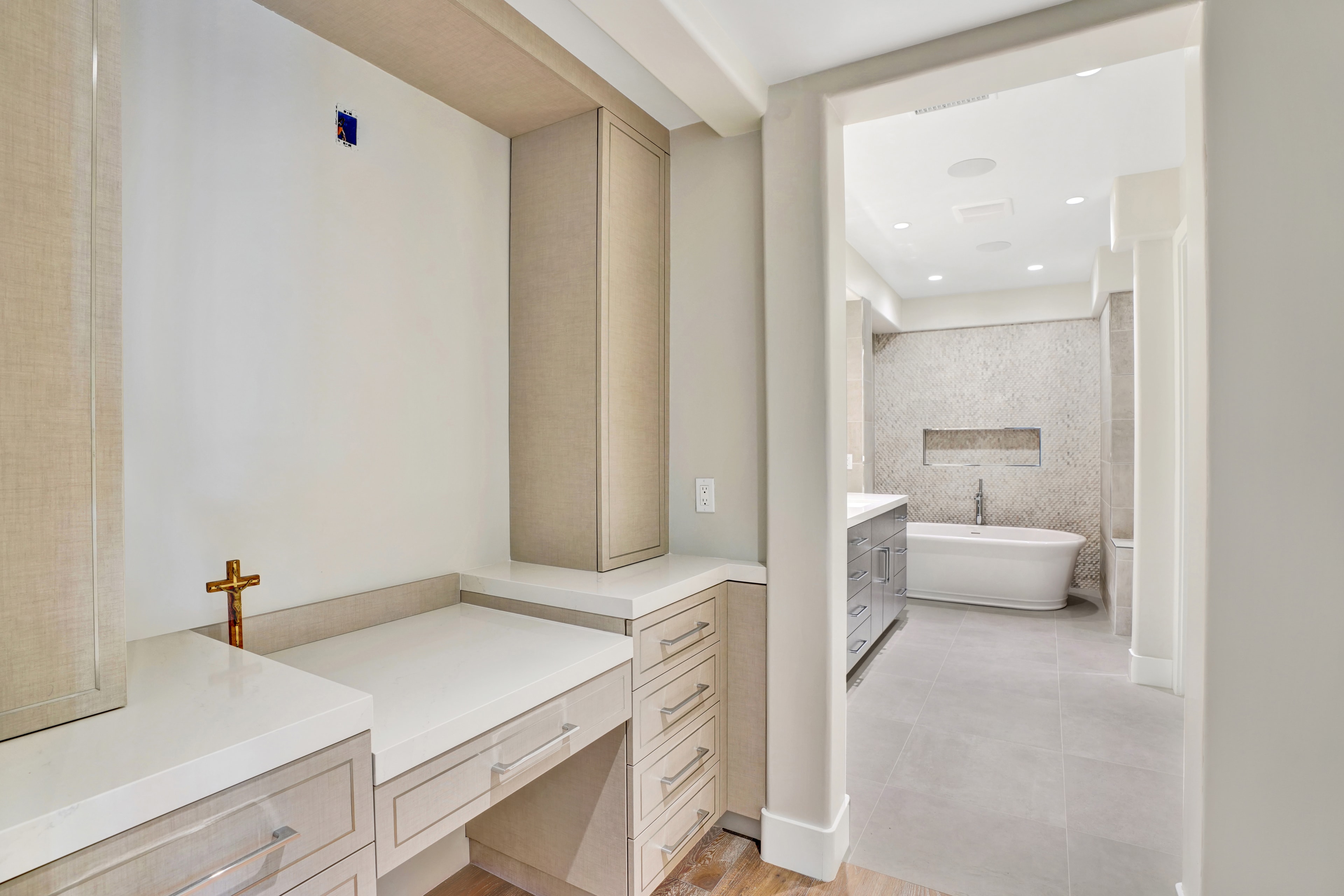 Bathroom remodel in Orange County CA — dual vanity with taupe mosaic stone tile accent wall, dual rectangular backlit LED mirrors, chrome widespread faucets, white quartz countertop, and crystal wall sconce between mirrors by Main Street Kitchen & Flooring