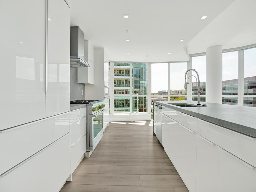 Kitchen island remodel in Irvine CA — quartz waterfall countertop with undermount sink and city skyline views by Main Street Kitchen & Flooring